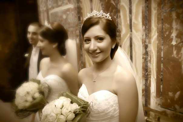 Smiling bride in a tiara holding white roses