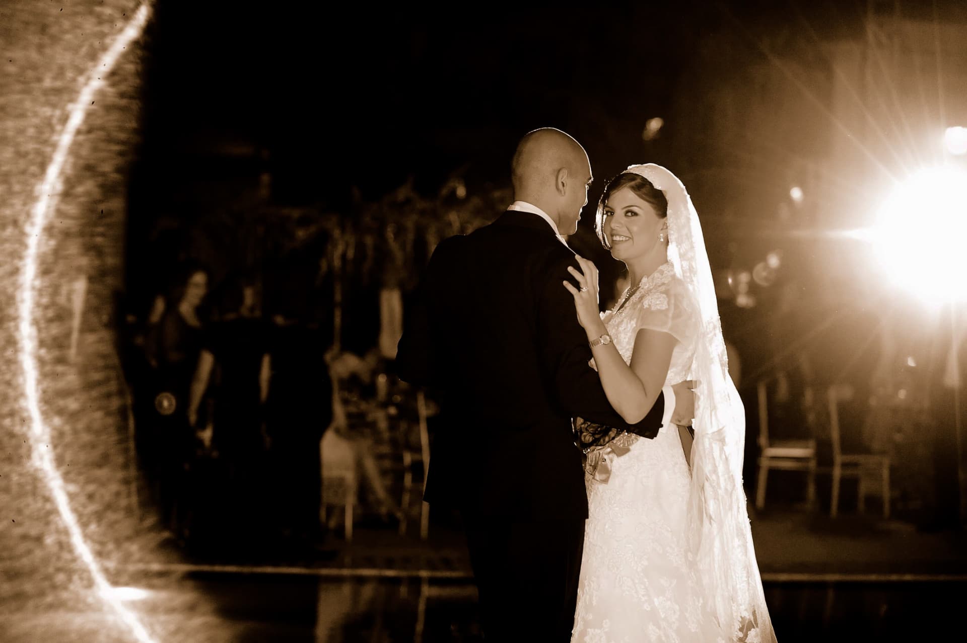 Bride smiling over the groom's shoulder during their first dance