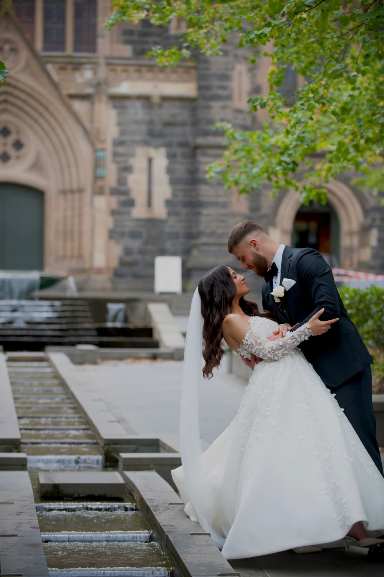 Couple embracing beside a cathedral water feature