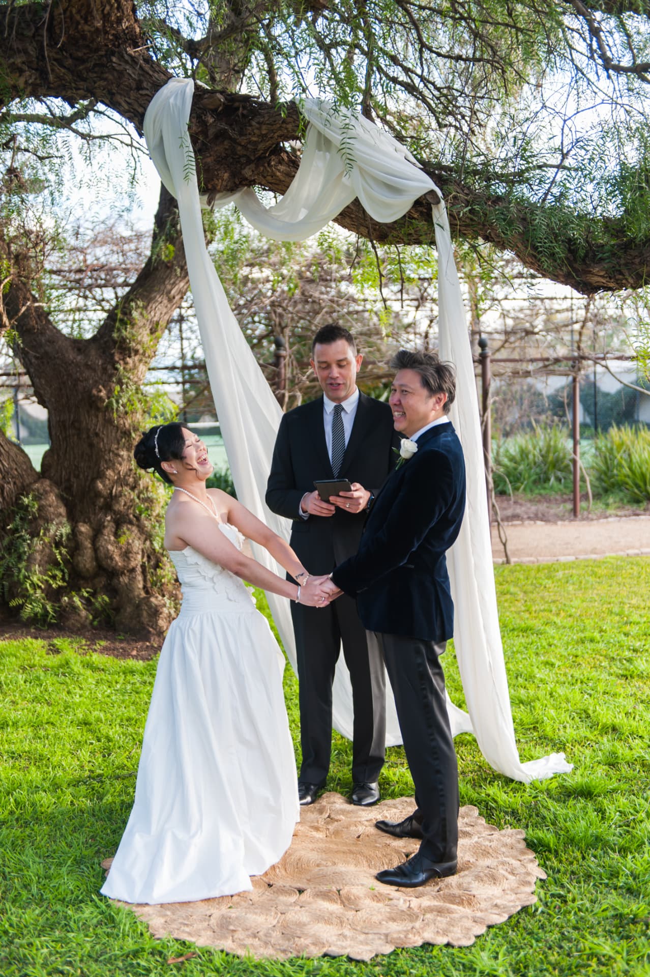 Garden ceremony under a draped tree with the celebrant