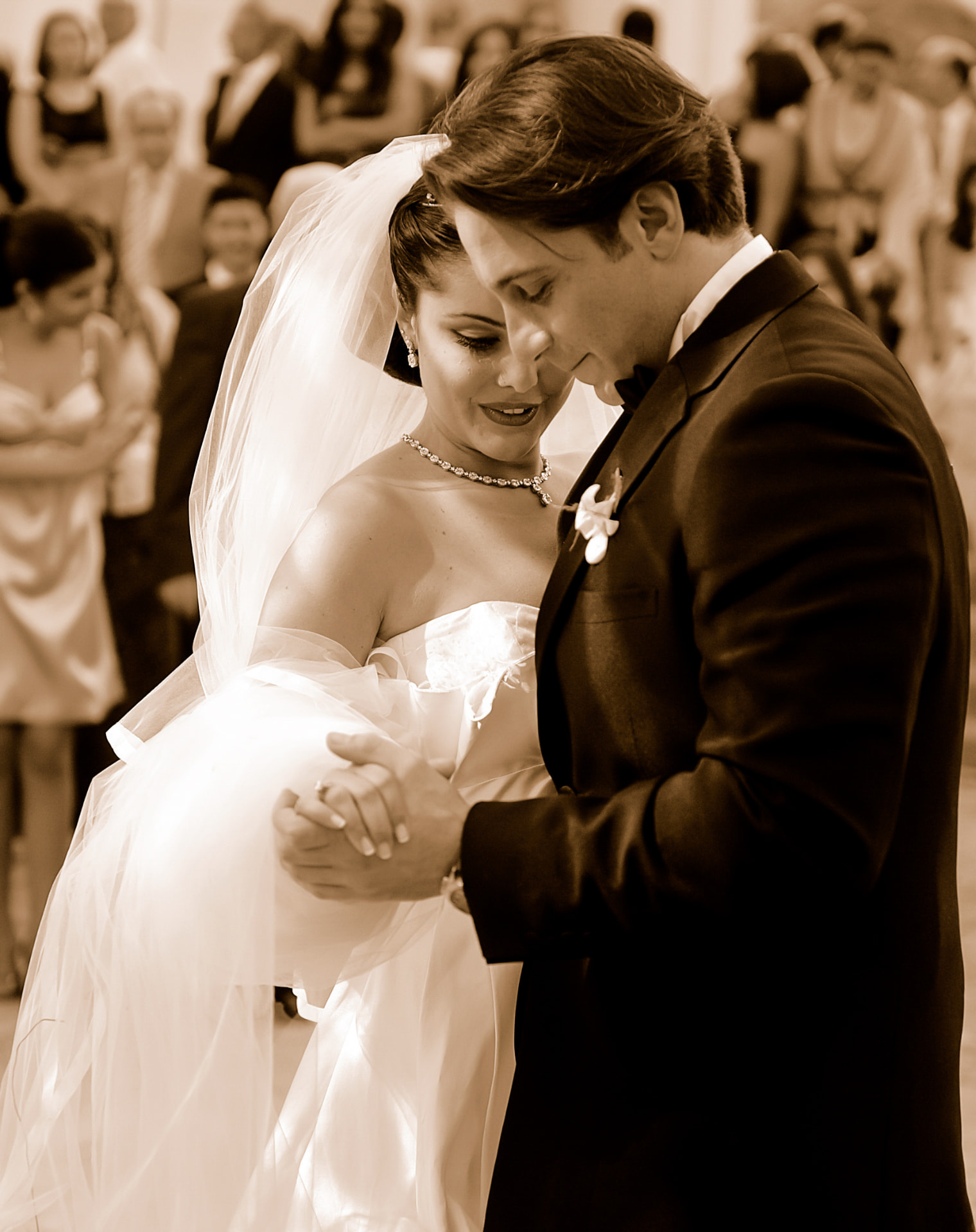 Couple sharing an emotional first dance in sepia
