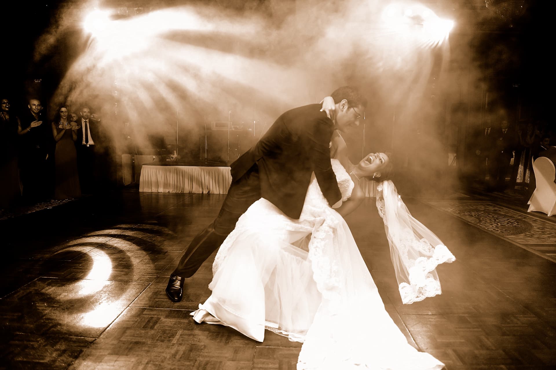 Couple dancing in a beam of light and haze