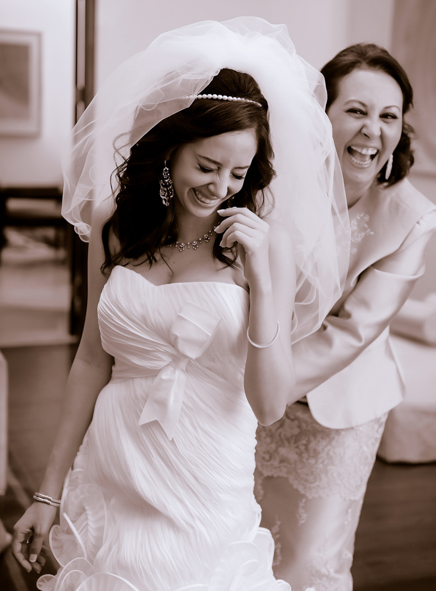 Bride laughing with her mother while getting ready