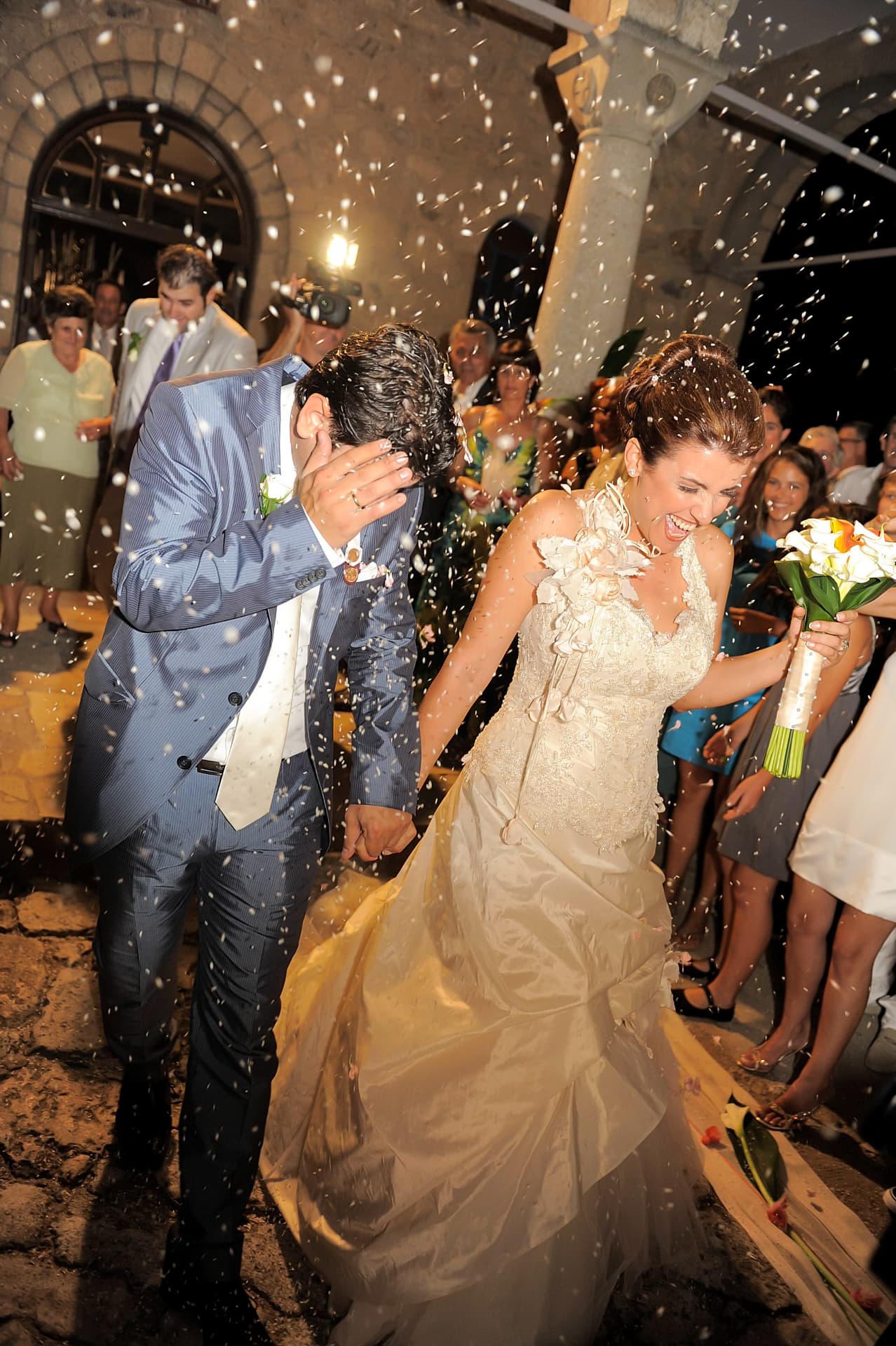 Couple showered with confetti as they leave the church at night