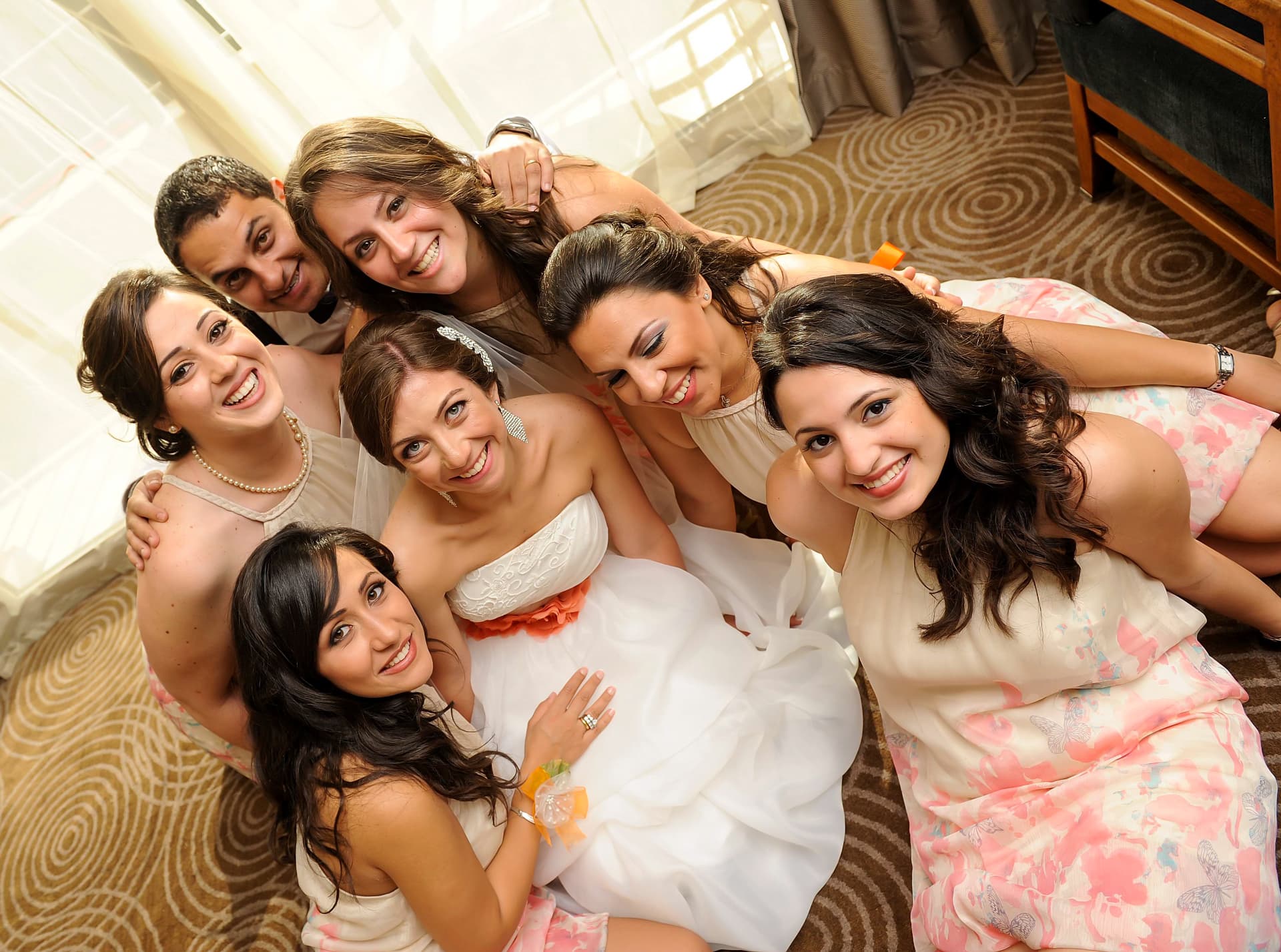 Bride laughing with her bridesmaids while getting ready