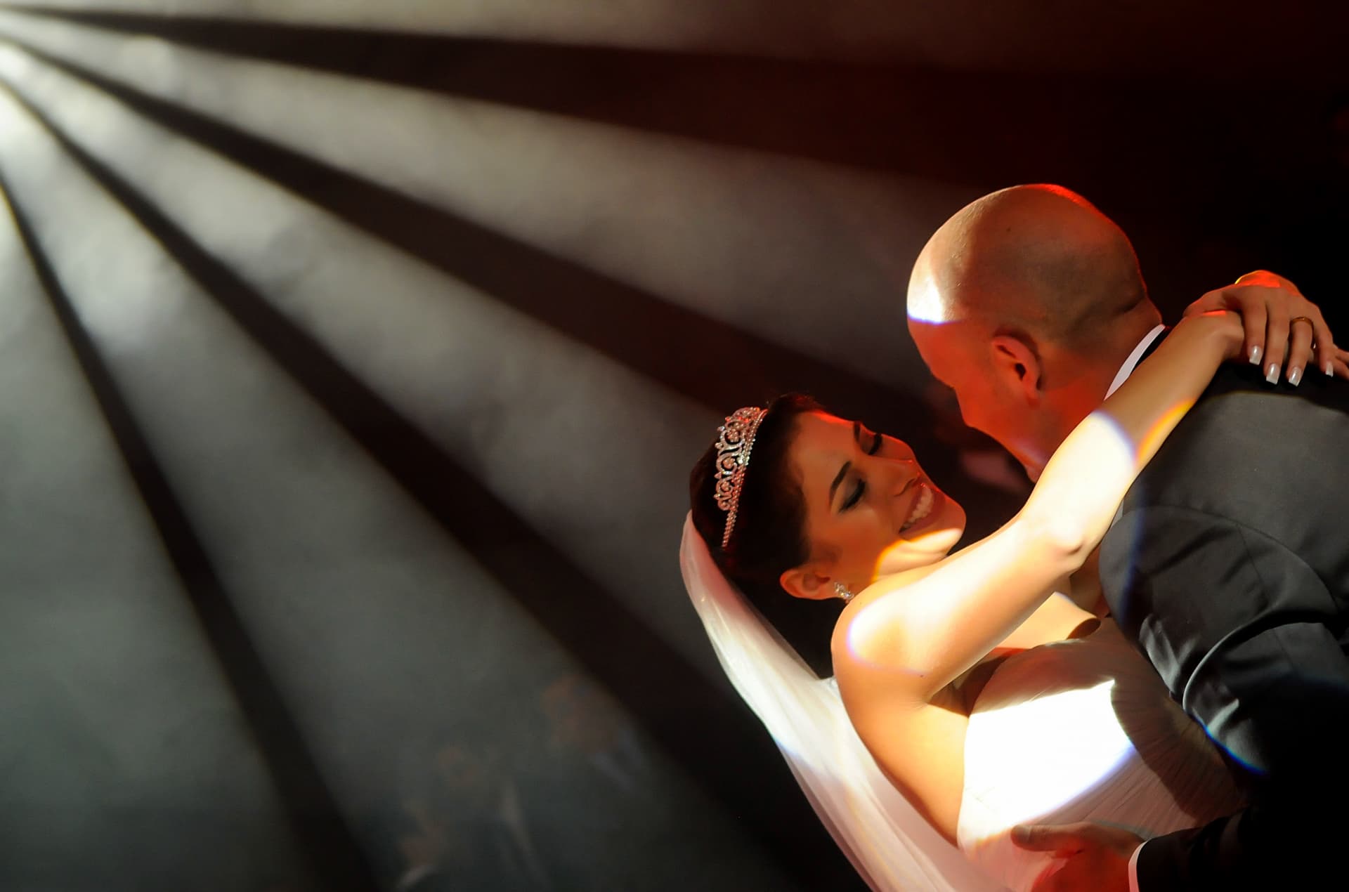 Couple dancing in dramatic beams of light