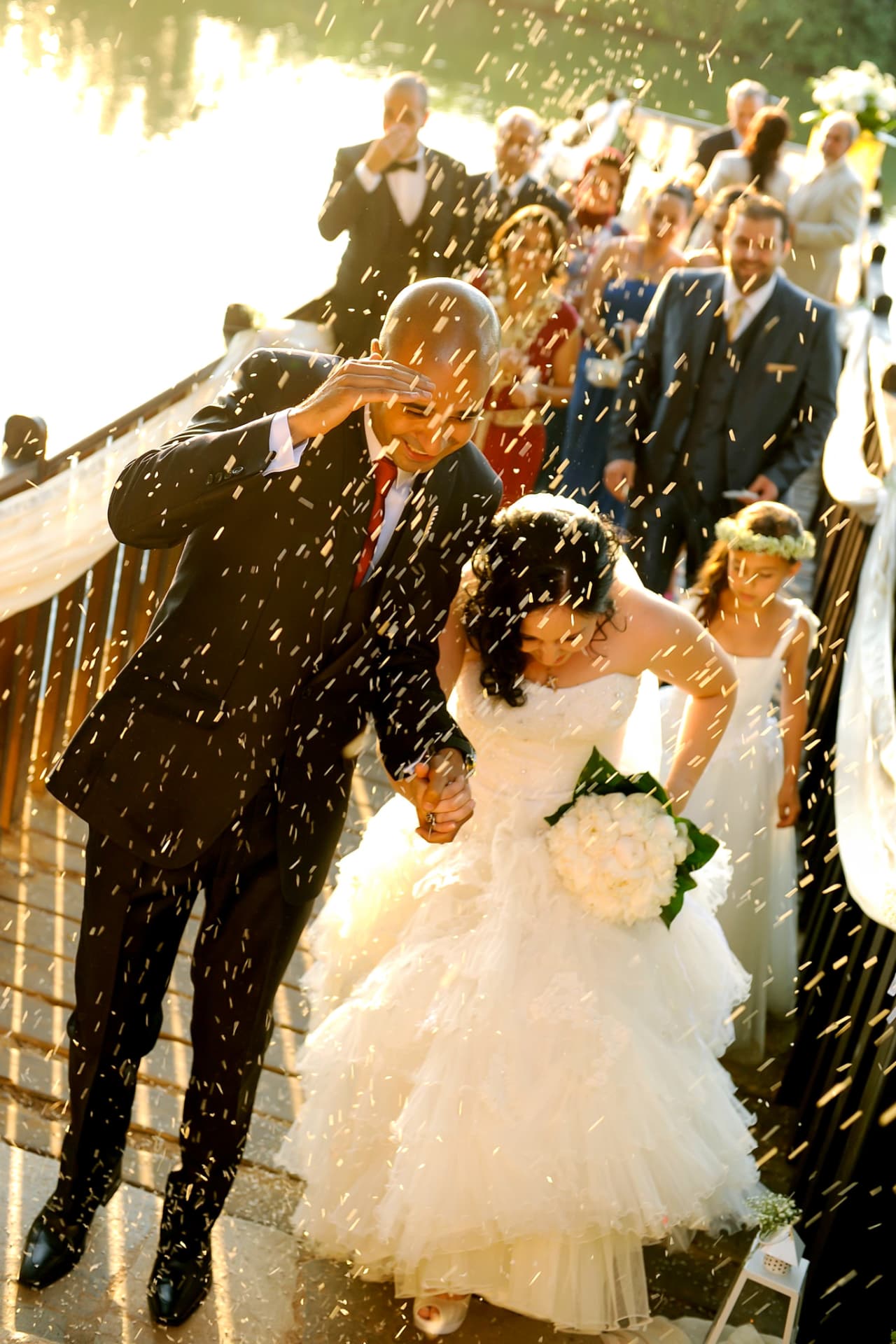 Couple showered with confetti as guests look on