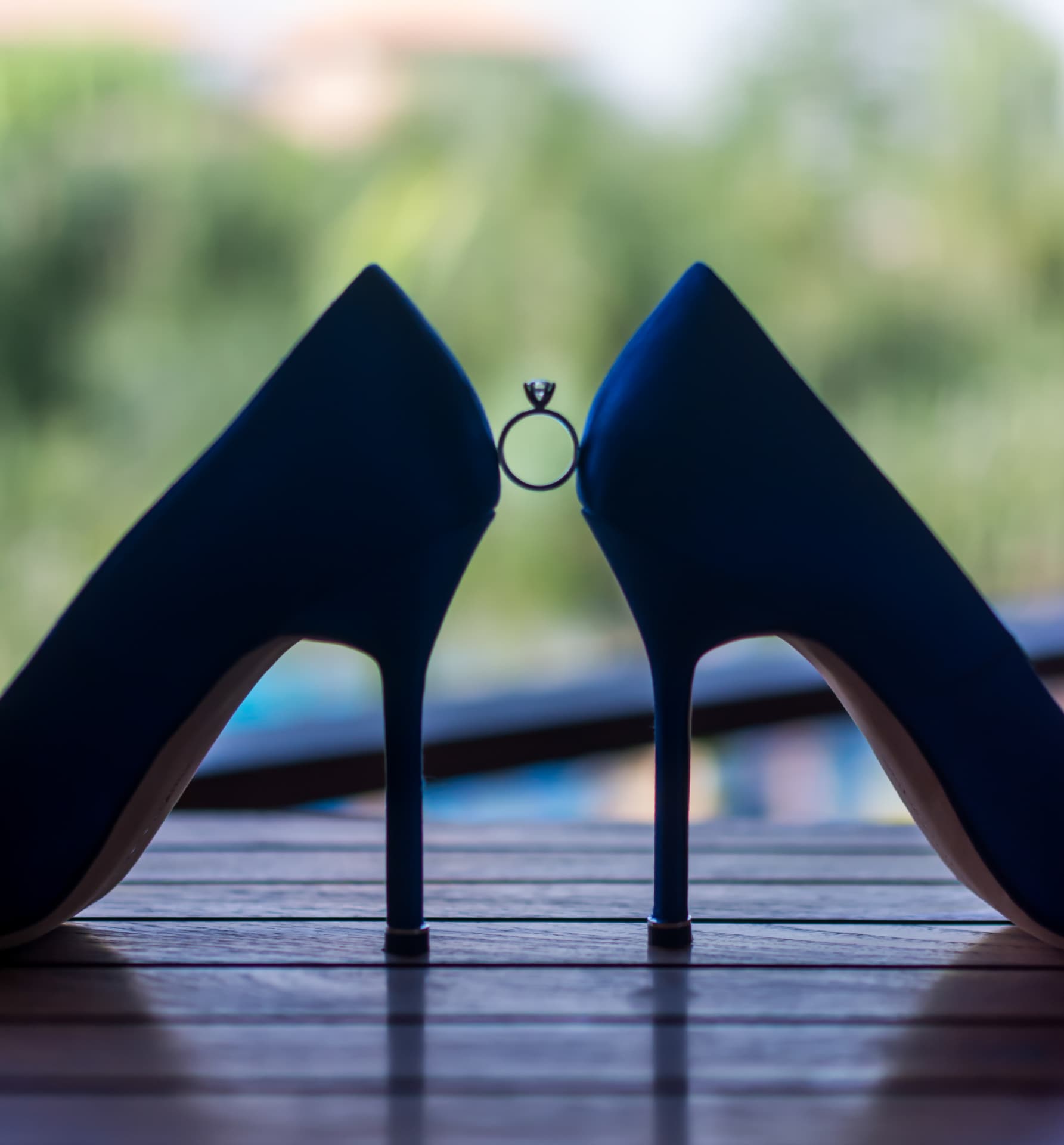 Engagement ring framed between navy bridal heels