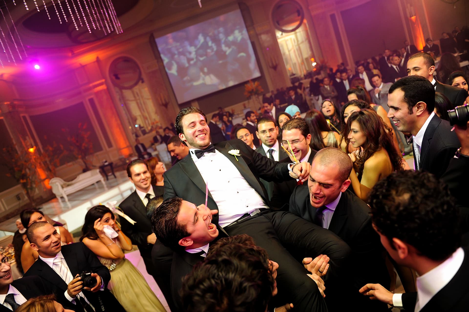 Friends lifting the groom during the reception